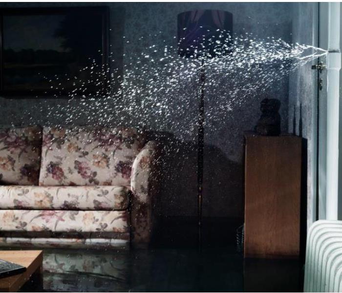 burst pipe spewing water in living room