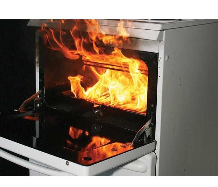 An open oven with flames pouring out